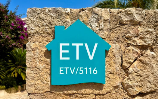 Tabliczka na drzwi w kształcie domu z napisem 'ETV/5116' na kamiennej ścianie.