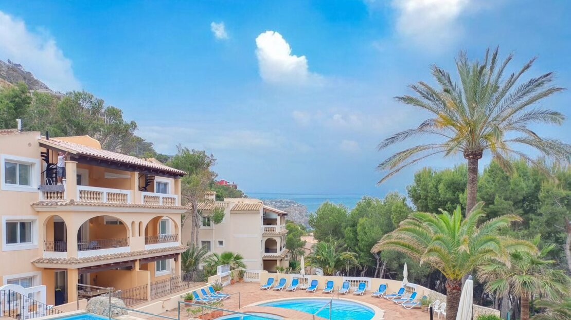 Helle Wohn- und Esszone in Nova Santa Ponsa mit Meerblick-Anmutung, weißen Wänden und eleganter Terrassentür; klarer, moderner Stil.