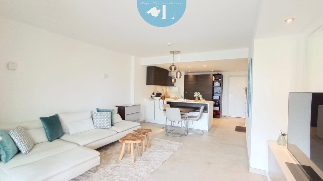 Helles Badezimmer mit Glasdusche, bodenebener Walk-in-Kabine und weißem Waschbecken sowie Badewanne; moderne Ausführung in Port Andratx mit Holz-Ablage.